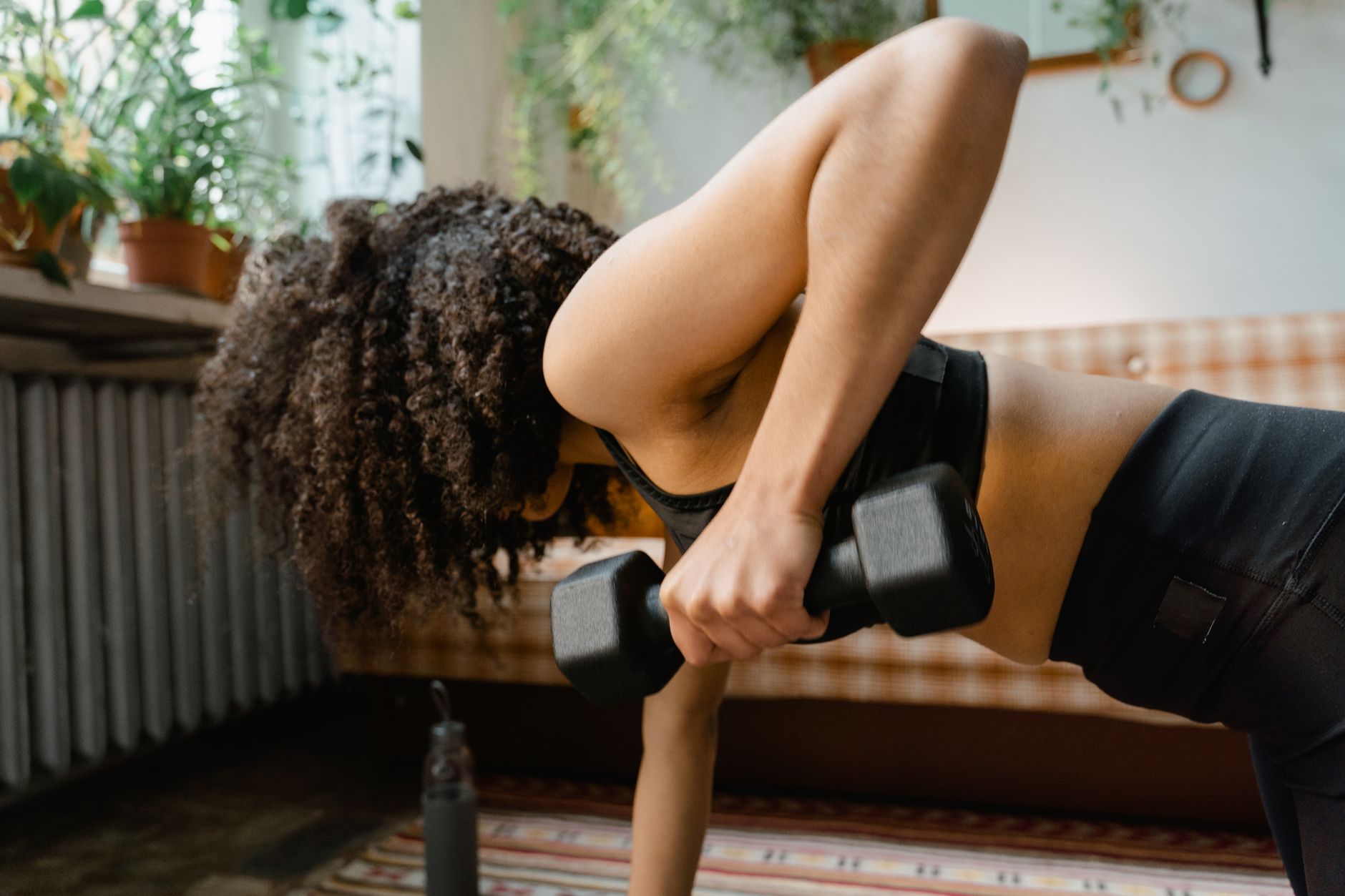 African American woman working out with dumbbells in an indoor setting, promoting a healthy lifestyle. — 12 Benefits of Mindf