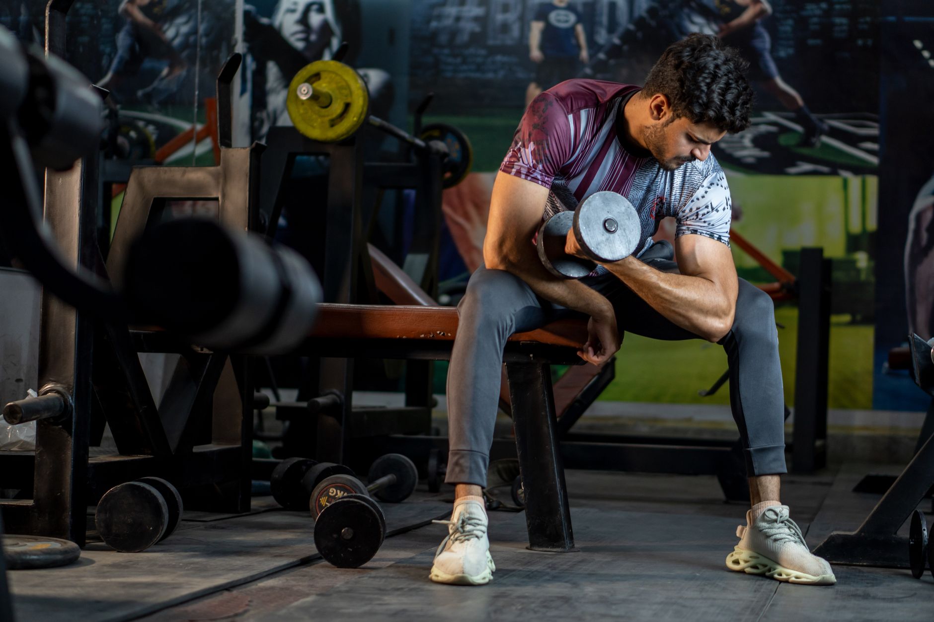 A muscular man working out in a gym, lifting a dumbbell for strength training. — Everything you need to know about Nutrition
