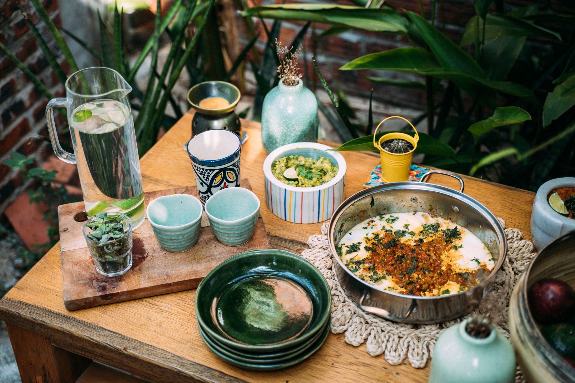A colorful outdoor table setup with various dishes, cups, and a pitcher of water. — Process of Fish gelatin production and it