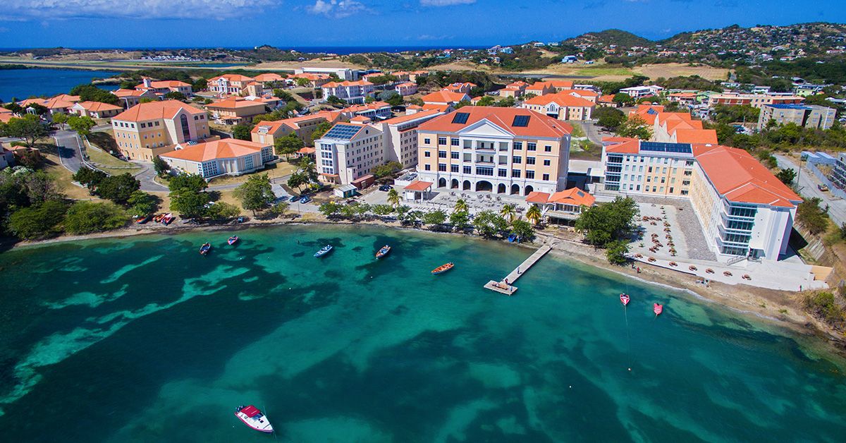 Aerial view of a coastal town with colorful buildings and boats moored in the water